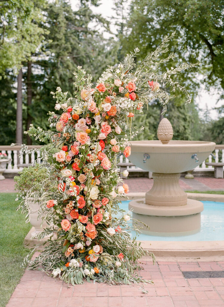 citrus inspired wedding arch with peonies, roses, cosmos and ranunculus at lairmont manor