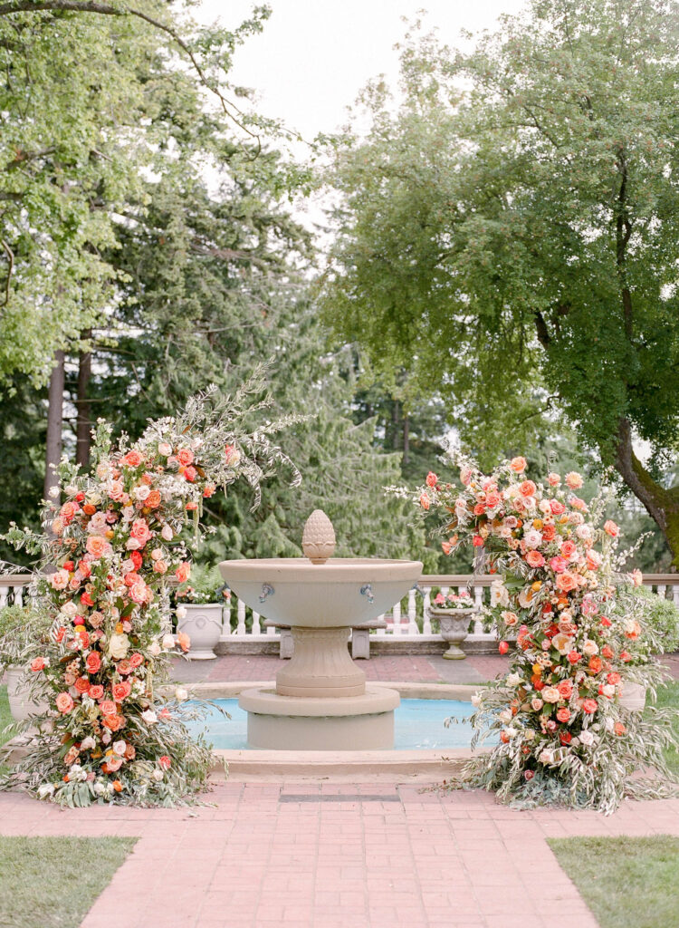 citrus inspired broken flower arch with peonies, roses, cosmos and ranunculus at lairmont manor